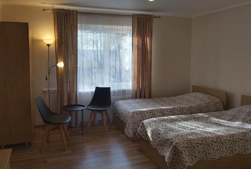 a hotel room with two beds and a table and chairs at Robeda in Kybartai
