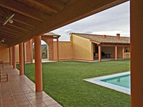 an outdoor patio with a yard and a swimming pool at Su Massaiu in Turri