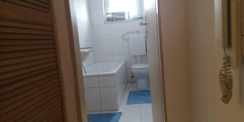 a white bathroom with a sink and a toilet at Apartment Goldberg in Sindelfingen