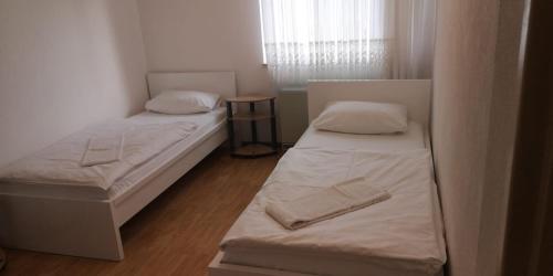 two beds in a small room with a window at Apartment Goldberg in Sindelfingen