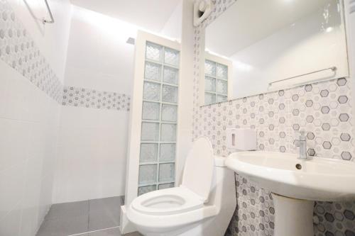 een witte badkamer met een toilet en een wastafel bij Thaiphiphat house in Bangkok