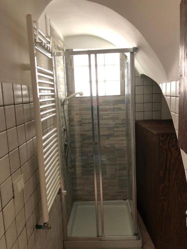 a shower with a glass door in a bathroom at La casa sulla piazza (Historic apartment) in Enna