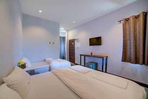 a hotel room with a bed and a tv at The Sleep Resort in Chiang Mai