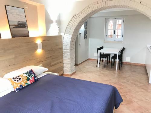 1 dormitorio con 1 cama y 1 mesa con sillas en Le Coste Casa Vacanze, en Scarlino