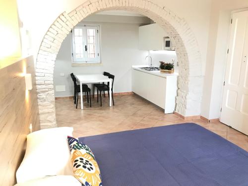 cocina y sala de estar con arco en Le Coste Casa Vacanze, en Scarlino