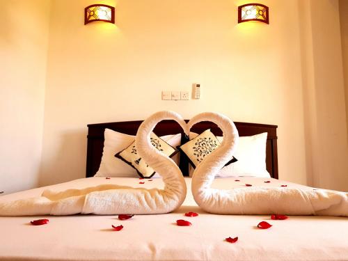 two swans made to look like hearts sitting on a bed at Jaye's Homestay in Kandy