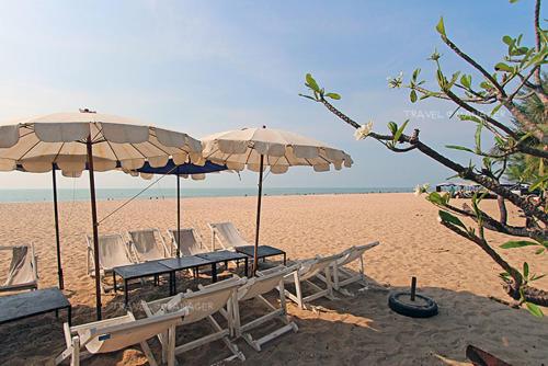a group of chairs and umbrellas on a beach at Panjai's Place in Cha Am