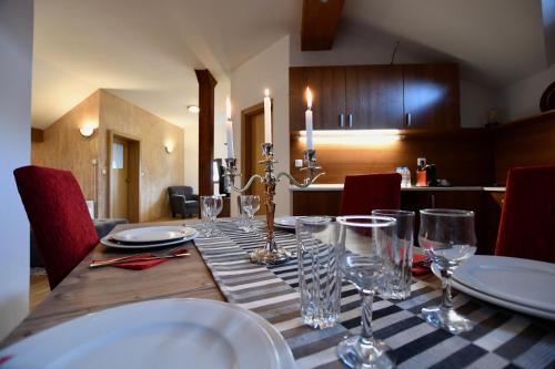 a table with glasses and plates on top of it at Dolomiti Apartments in Bansko