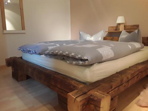 a bed made out of a wooden bed frame at Ferienwohnung Döhlerwald in Klingenthal