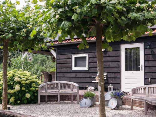 two benches in front of a log cabin at Bed & Breakfast De Schuur Inn in Numansdorp