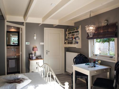 um quarto com uma cama, uma mesa e uma cozinha em Bed & Breakfast De Schuur Inn em Numansdorp