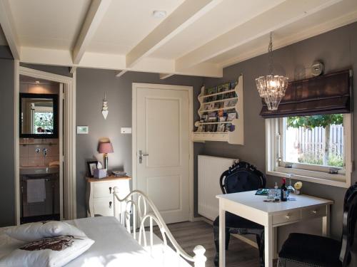 a bedroom with a bed and a table and a kitchen at Bed & Breakfast De Schuur Inn in Numansdorp