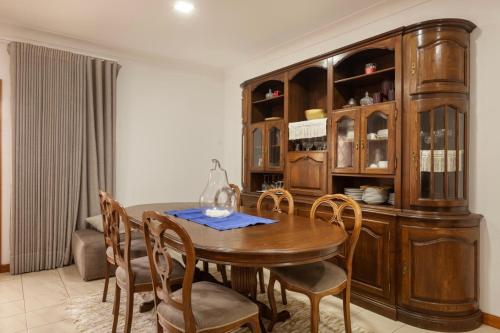 a dining room with a wooden table and chairs at Vivenda Mar e Terra in Apúlia