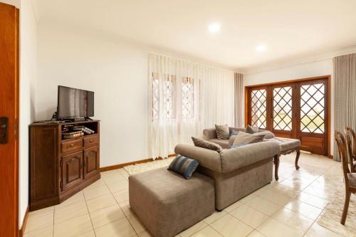 a living room with a couch and a tv at Vivenda Mar e Terra in Apúlia