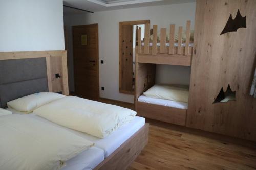 two beds in a room with two bunk beds at Alpenhof Annaberg in Annaberg im Lammertal