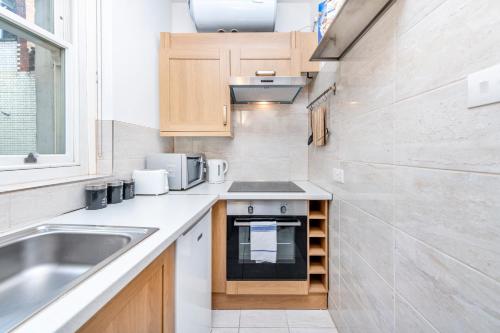 a small kitchen with a sink and a stove at Soho Central Apartments in London