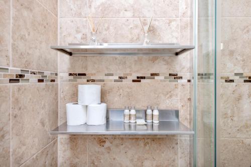 ein Badezimmer mit einem Waschbecken und einem Regal mit Handtüchern in der Unterkunft Soho Central Apartments in London