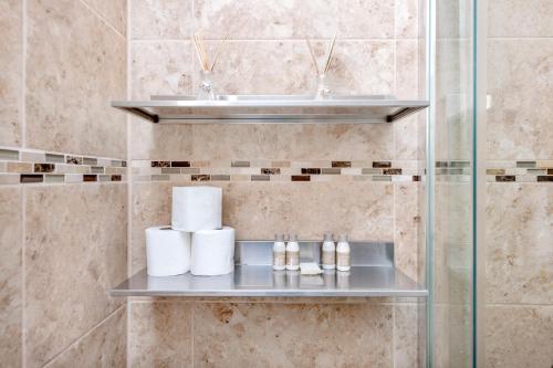 a bathroom with a sink and a shelf with towels at Soho Central Apartments in London