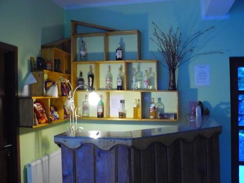 a bar with a shelf with bottles on it at Cabana Delfinul in Dubova