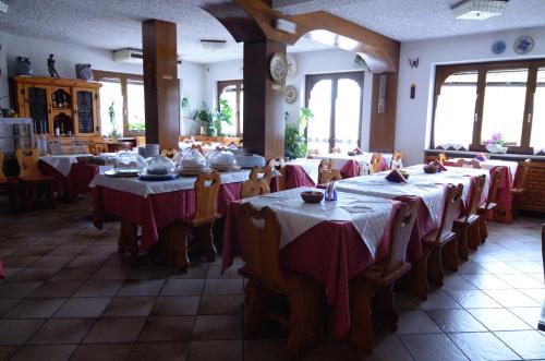 a row of tables in a restaurant with red table cloths at Albergo Mirella in Belluno