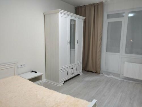 ein weißes Schlafzimmer mit einem großen weißen Schrank in der Unterkunft 1-к кв ж/м Радужный in Odessa