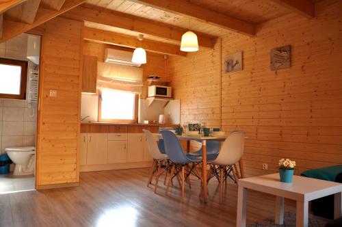 a kitchen and dining room with a table and chairs at Słoneczny Przystanek in Jarosławiec