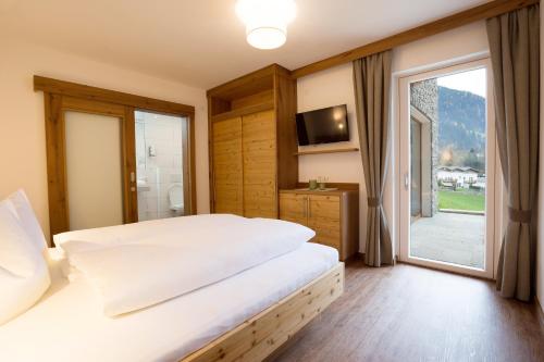 1 dormitorio con cama grande y ventana grande en Appartement Freiblick, en Ramsau im Zillertal