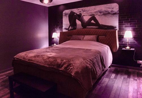 un dormitorio con una cama con una persona puesta en ella en Suite avec Jacuzzi et Sauna Privée, en Évreux