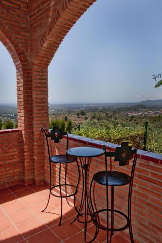 a patio with two chairs and a bar with a view at Can Prats in Ríudecañas