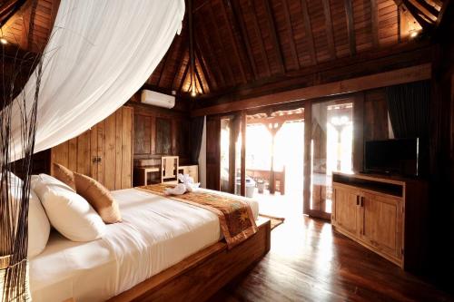 - une chambre dotée d'un grand lit avec moustiquaire dans l'établissement Bumbung Sari Villa, à Ubud