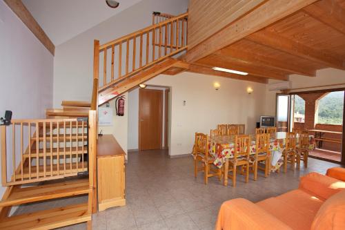 a living room with a staircase and a table and chairs at Can Prats in Ríudecañas