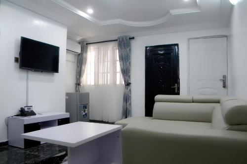 a living room with a couch and a tv at JAYBRITT LUXURY APARTMENT in Ibadan