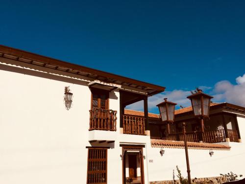 a large white building with a balcony on top of it at Hotel Campestre El Portón de Los Jeroglíficos in Ramiriquí