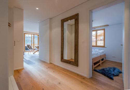 a bedroom with a mirror and a bed in a room at Panoramapark Soleil Chalet B in Wengen