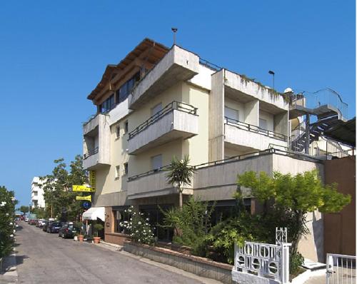 un grand bâtiment avec des balcons sur le côté d'une rue dans l'établissement Ristorante Hotel Lucia - 100 mt dal mare, à Giulianova