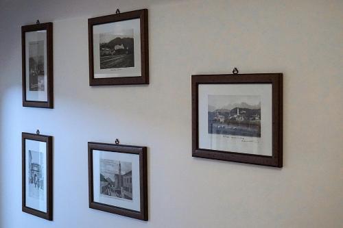 een muur met ingelijste foto's aan een muur bij B&B La Pecora Nera in Belluno