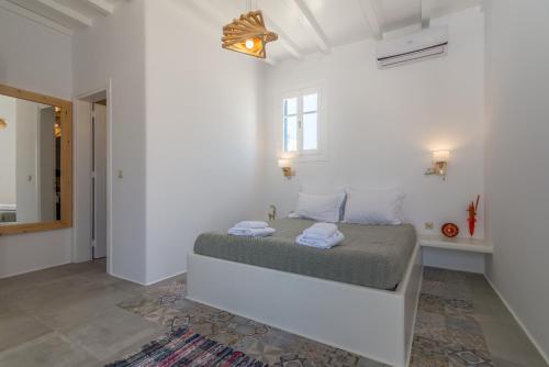 a bedroom with a bed in a white room at Manolis And Filio Home -By The Sea in Pachaina