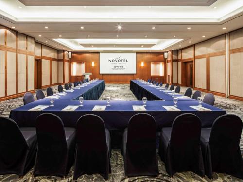 a conference room with rows of tables and chairs at Novotel Ambassador Seoul Gangnam in Seoul