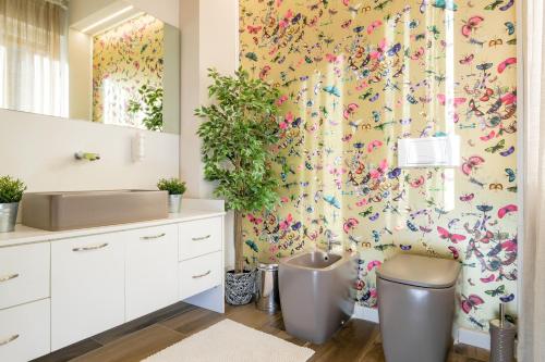 bagno con servizi igienici e carta da parati floreale di Olimpia House room a Verona