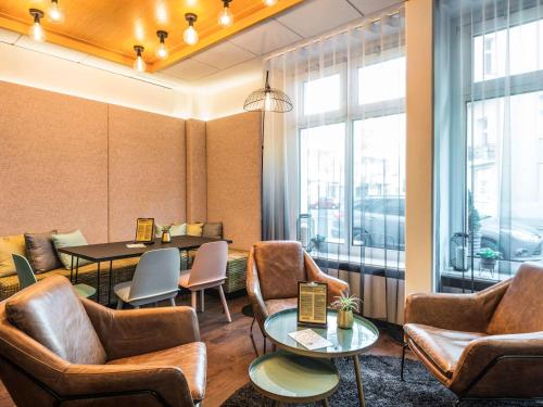a waiting room with leather chairs and a table at Mercure Hotel Berlin Zentrum Superior in Berlin