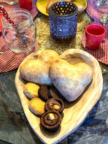 a wooden plate with heart shaped biscuits and cookies at Il Roccolino in Valsecca