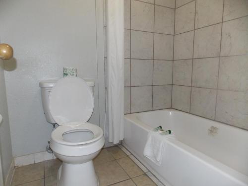 a bathroom with a toilet and a bath tub at Augusta Best Inn in Augusta