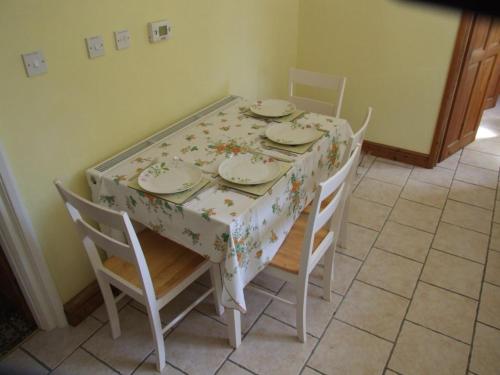 a dining room table with chairs and a floral table cloth at firtrees in Selby