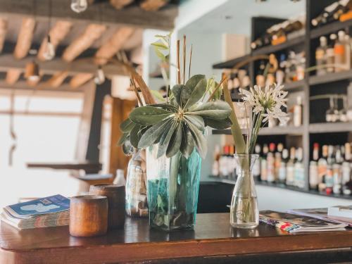 a table with three vases with flowers on it at Posada Azul Marino in José Ignacio