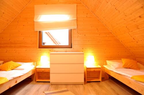 a room with two beds in a wooden cabin at Słoneczny Przystanek in Jarosławiec