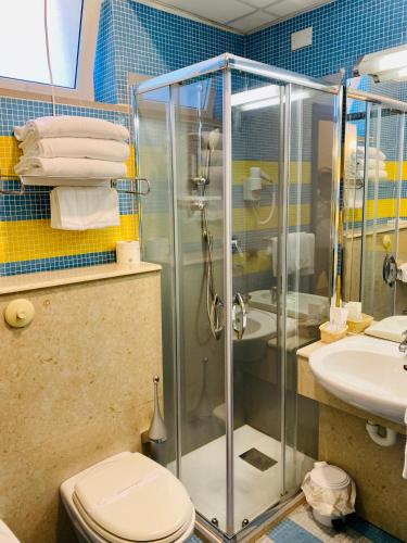 a bathroom with a shower and a toilet and a sink at Hotel Della Baia in Portovenere