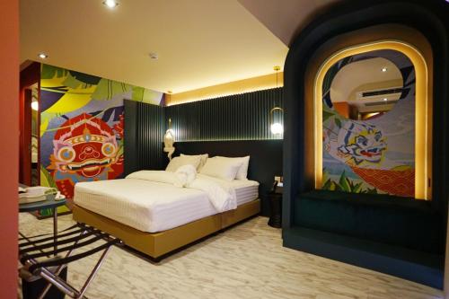 een slaapkamer met een bed met een schilderij aan de muur bij 4 Monkeys Hotel in Bangkok