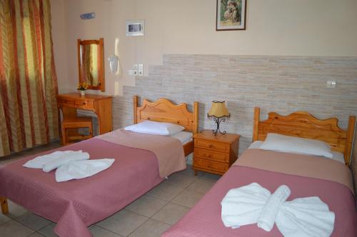 a bedroom with two beds with towels on them at Anaxos Gardens in Anaxos