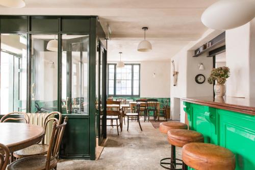 a restaurant with green cabinets and tables and chairs at The Bull Inn in Totnes