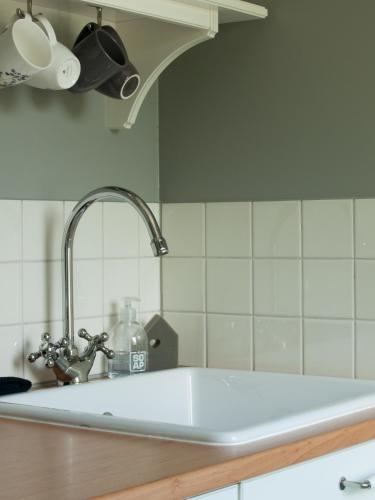 a kitchen counter with a sink and aaucet at Bed & Breakfast De Schuur Inn in Numansdorp